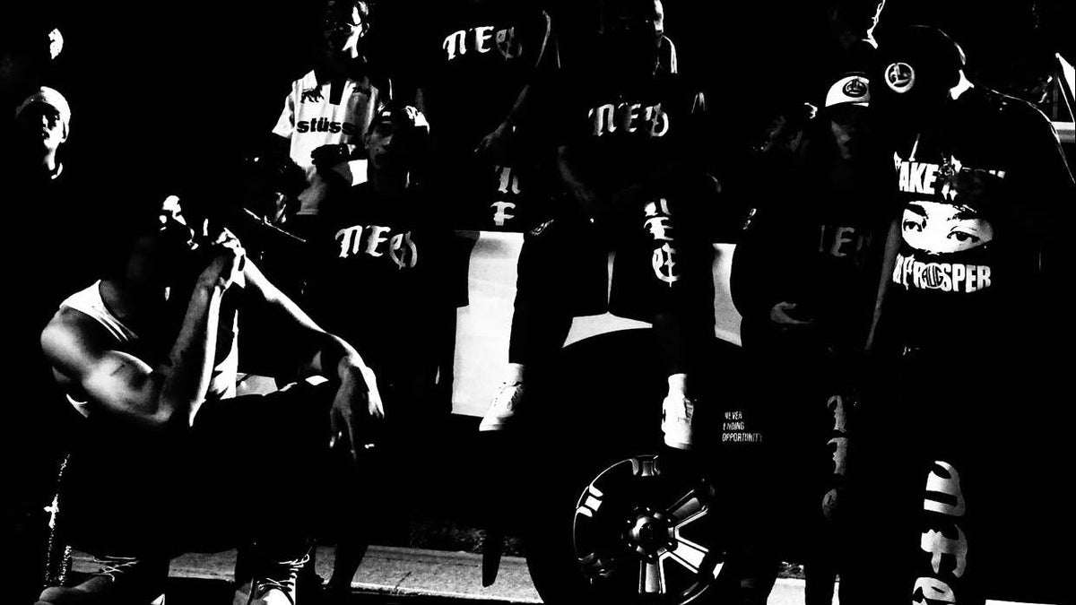 The Neo crew photographed at night in high-contrast black and white, wearing NEO tees